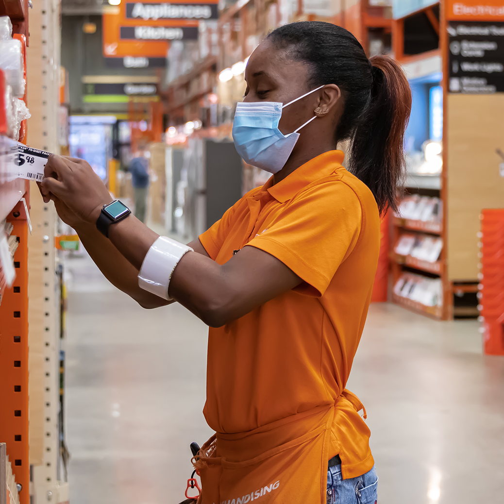 Woman working in a Home Depot store while wearing a mask